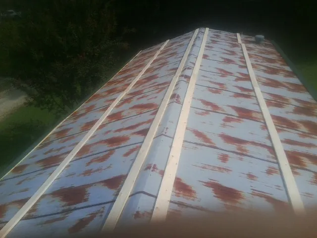 Rusted metal roof panels with new wood purlins before replacement — Storm Damage Roof Repair in Humble by Roofing Brothers